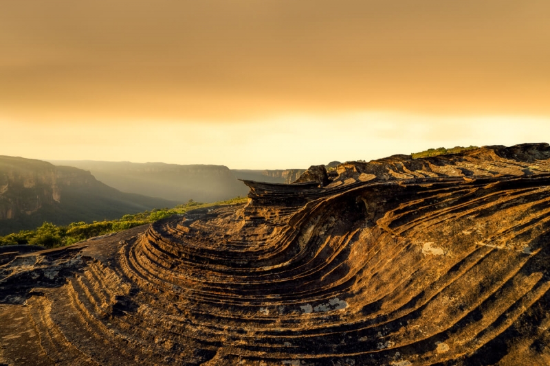 wind textured sandstone carved in waves at sunset
