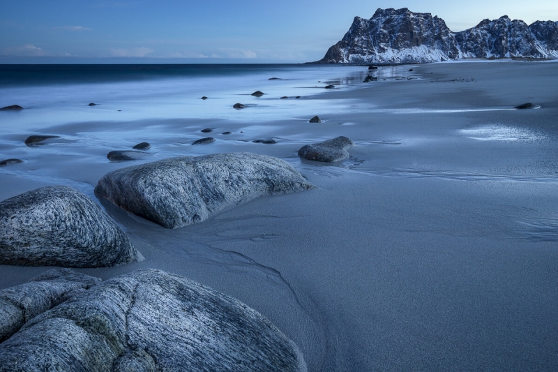 blue hour Uttakleiv beach, textured rocks mountain in distance