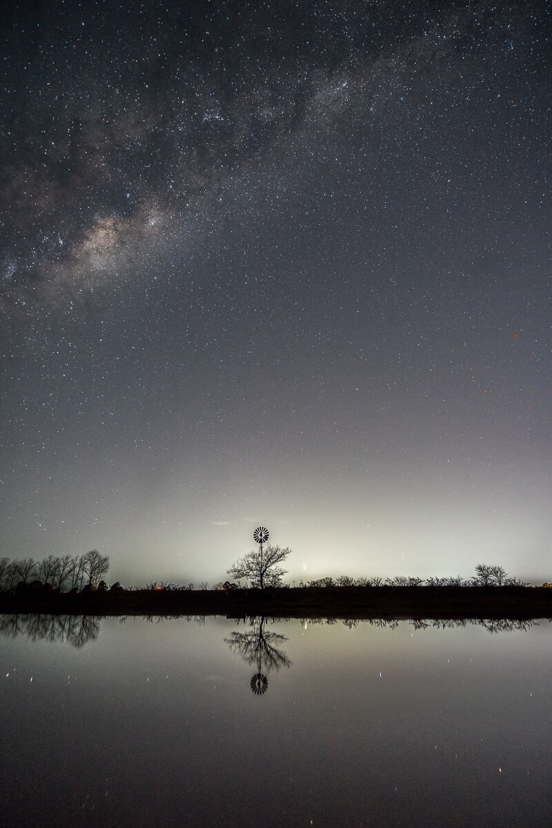 Milky Way rising over windmill and lake