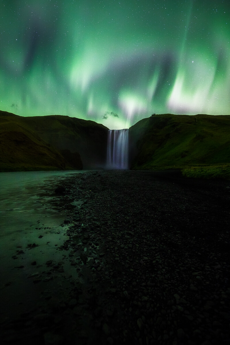 northern lights at skogarfoss waterfall iceland