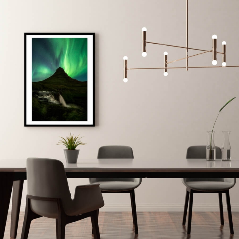 Northern lights dance behind Kirkjufell and kirkjufellsfoss