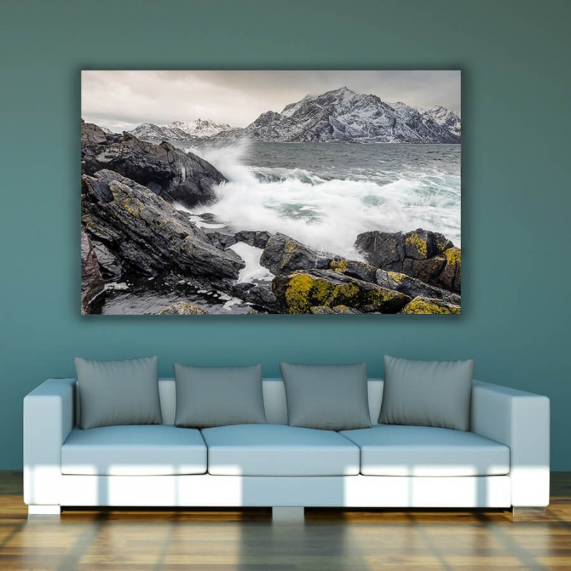 rough seas crashing against rocks, mountains in the distance